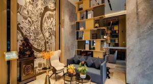 a living room with a blue couch and chairs at Echarm Hotel Hefei West Qilitang Metro Station in Hefei