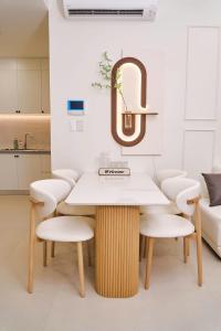 een tafel en stoelen in een keuken met een spiegel bij KNV Apartment in Thu Dau Mot