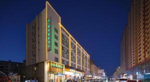 a large building on a city street at night at GreenTree Inn Luoyang Railway Station Wangfujing Wangcheng Park in Luoyang