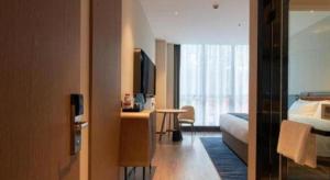 ein Hotelzimmer mit einem Bett und einem Fernseher in der Unterkunft Echarm Hotel Liuzhou Yaobu Ancient Town in Liuzhou