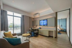 ein Wohnzimmer mit Sofa und Fernseher in der Unterkunft Echarm Hotel Fangchenggang Qisha in Gongche