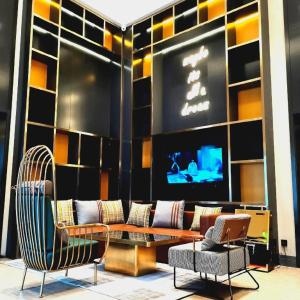 une pièce avec une table, des chaises et une télévision dans l'établissement Premier City Comfort Hotel Wuhan Yellow Crane Shouyi Road Metro Station, à Wuhan