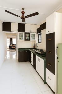 une cuisine avec des placards noirs et blancs et un plafond dans l'établissement Entire Home in Pune City Near Airport India 3BHK, à Jāmb