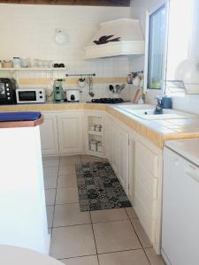a kitchen with white cabinets and a tile floor at Ti kaz Annah in Le Tampon +9 photos