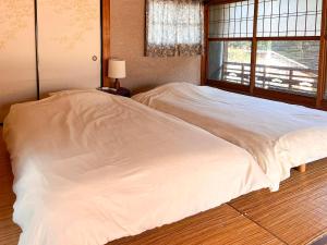 Ένα ή περισσότερα κρεβάτια σε δωμάτιο στο ゲストハウスサンテ