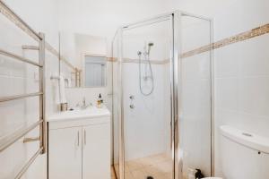 a white bathroom with a shower and a sink at A Market Place Mudgee - Walk to Town Centre & Parks in Mudgee +34 photos