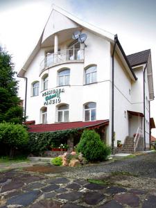 a large white building with a sign on it at Béluci Panzió in Odorheiu Secuiesc