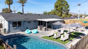 a house with a swimming pool with chairs and umbrellas at Heated Saltwater Pool I Old Town I BBQ I Firepit in Scottsdale