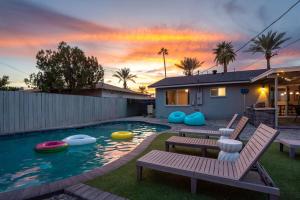 a backyard with a pool with benches and a house at Heated Saltwater Pool I Old Town I BBQ I Firepit in Scottsdale