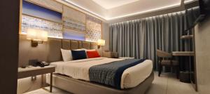 a hotel room with a bed and a desk and a room at SILVER INN, Andheri in Mumbai