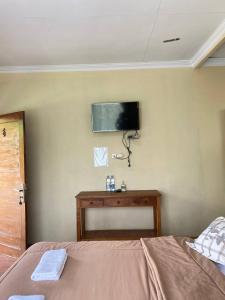 a bedroom with a bed and a tv on the wall at Opak Village Bed & Breakfast in Bantul +28 photos