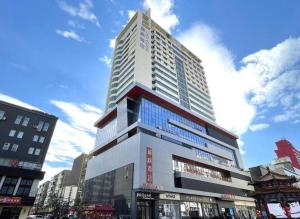 ein hohes Gebäude mitten in einer Stadt in der Unterkunft Lavande Hotel Shenyang Middle Street Walking Street Metro Station in Shenyang