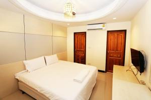 a bedroom with a white bed and a tv at T3 Residence in Bangkok