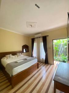 a bedroom with a bed and a large window at Opak Village Bed & Breakfast in Bantul