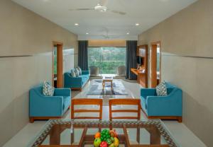 a living room with blue chairs and a table at The Fog Munnar (Resort & Spa) in Munnar