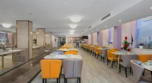 ein Esszimmer mit Tischen und gelben Stühlen in der Unterkunft Vienna Hotel Shandong Qingdao Taidong Pijiu Street Liaoning Road in Qingdao