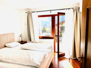 a bedroom with a white bed and a window at Haus Auszeit in Buchau