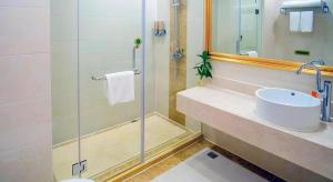 a bathroom with a sink and a glass shower at Vienna Hotel Shanghai Songjiang Market Miaoqian Street in Chengxi