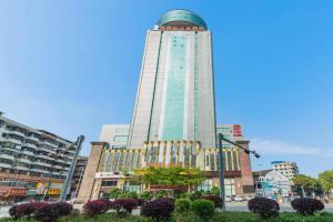 ein hohes Gebäude mit einer Kuppel darauf in der Unterkunft Venus Royal Hotel Guangdong Meizhou Huangjia Mingdian in Meizhou