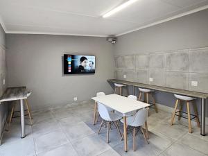 - une salle d'attente avec une table et une télévision murale dans l'établissement Beds Inn Midrand, à Midrand
