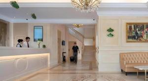 a person walking down a hallway in a building at Vienna Hotel Shenzhen Window of the World Qiaochengdong Metro Station in Shenzhen