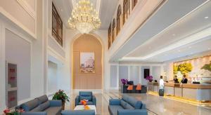 eine Lobby mit blauen Stühlen und einem Kronleuchter in einem Hotel in der Unterkunft Vienna Hotel Beijing Changping Science and Technology Park in Ch'ang-p'ing-hsien