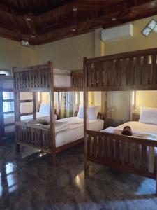 a bedroom with two bunk beds with white sheets at Sunset Backpackers Hostel in Nongkhiaw