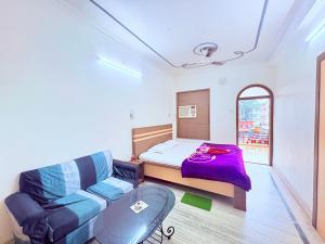 a small bedroom with a bed and a couch at বীণাপানি হোটেল & রেস্টুরেন্ট Binapani Tarapith in Tarapith