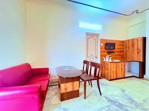 a living room with a red couch and a table at বীণাপানি হোটেল & রেস্টুরেন্ট Binapani Tarapith in Tarapith