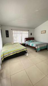 une chambre avec deux lits et une fenêtre dans l'établissement Casa campestre Finca Renacer, à San Francisco