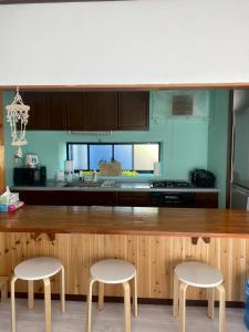 a kitchen with two chairs and a wooden counter with a counter top at Lagoon藍yoron 一棟貸し in Yoron