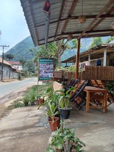 a restaurant with a table and chairs and a sign at Sunset Backpackers Hostel in Nongkhiaw