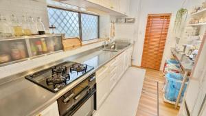 a kitchen with a sink and a stove top oven at MyBound Homestay Zushi in Zushi