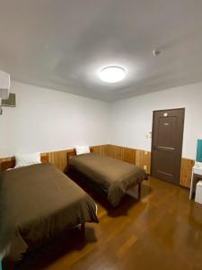 a room with two beds and a table and a lamp at Lagoon藍yoron 一棟貸し in Yoron