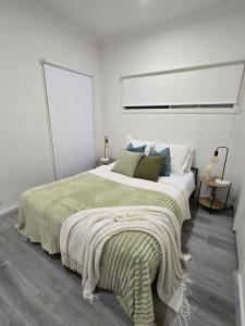 Un dormitorio con una cama con una manta verde encima. en Beautiful & Modern 2BR Residence in Doncaster East, en Doncaster East
