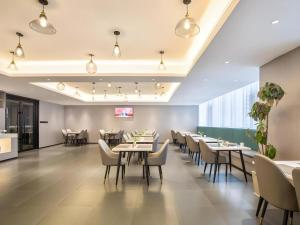 ein Esszimmer mit Tischen und Stühlen in der Unterkunft Green Tree Inn Suzhou Wujiang East Tai Lake Tourism Resorts in Suzhou