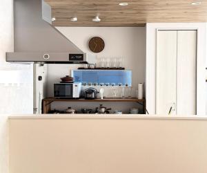 cocina con fogones y reloj en la pared en The Ogawa 小川 Live like a local, en Inzai