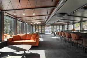 eine Lobby mit einem Sofa und einer Bar mit Stühlen in der Unterkunft Villa Rossa Luxury & Spa Residence in Narechenski Bani