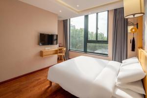 a hotel room with a bed and a large window at Meiwan Inn in Jiaxing