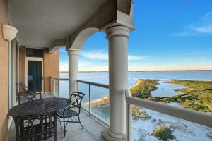 een balkon met een tafel en stoelen en uitzicht op het water bij 2 Portofino 1602 in Oriole Beach