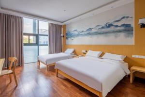 a hotel room with two beds and a large window at Meiwan Inn in Jiaxing +44 photos