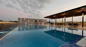 a large swimming pool with blue water in a building at J HOTEL in Kampong Kiulap