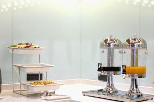 a buffet with two plates of food and a juicer at Borrman Hotel Korla Peacock River in Korla