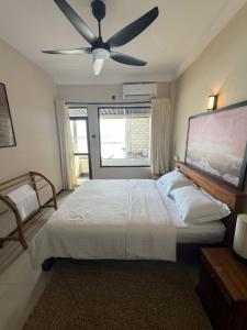 Un dormitorio con una cama con ventilador de techo. en Pelican Ahangama, en Ahangama