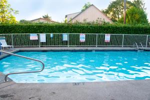Parkrose的住宿－俄勒岡州波特蘭一室公寓6號酒店，一座带金属围栏的大型游泳池