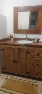 a bathroom with a sink and a mirror at Bangalô Rústico Duplex - Retiro Andaluz in Brumadinho