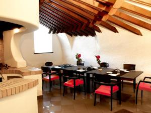 comedor con mesa negra y sillas rojas en Jet Hotel, en Caselle Torinese