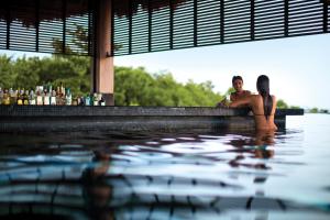 a man and a woman sitting in a swimming pool at Nizuc Resort & Spa in Cancún