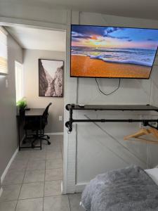einen Flachbild-TV an einer Wand in einem Schlafzimmer in der Unterkunft Las Casita-Cozy Apartment near Airport, Downtown, UTEP, Fort Bliss in El Paso