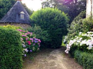a garden with pink and white flowers and a house at Séjour romantique ou professionnel au Château isigny, Charme et feu de cheminée in Isigny-le-Buat
